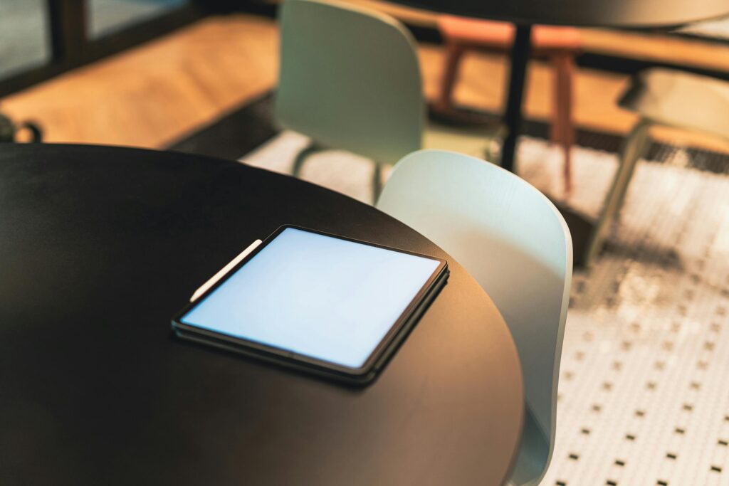 Digital tablet on a table in a modern cafe interior with soft lighting.